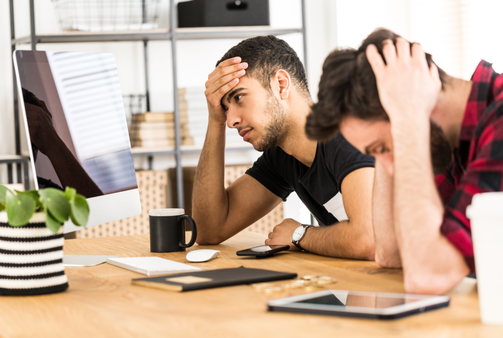 two frustrated men facing their computers